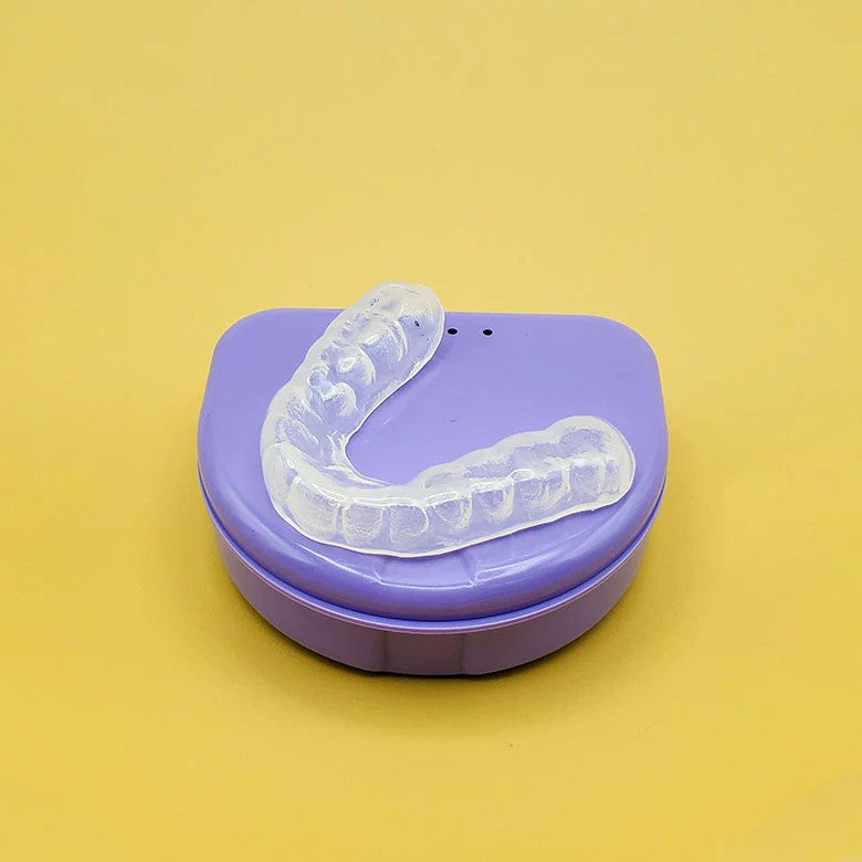 hard dental guard sitting on top of a purple case